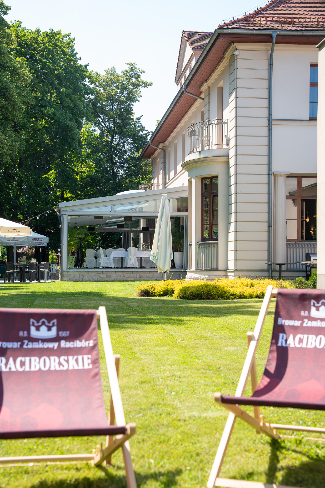 Hotel Gorczowski latem — patio i trawnik z leżakami