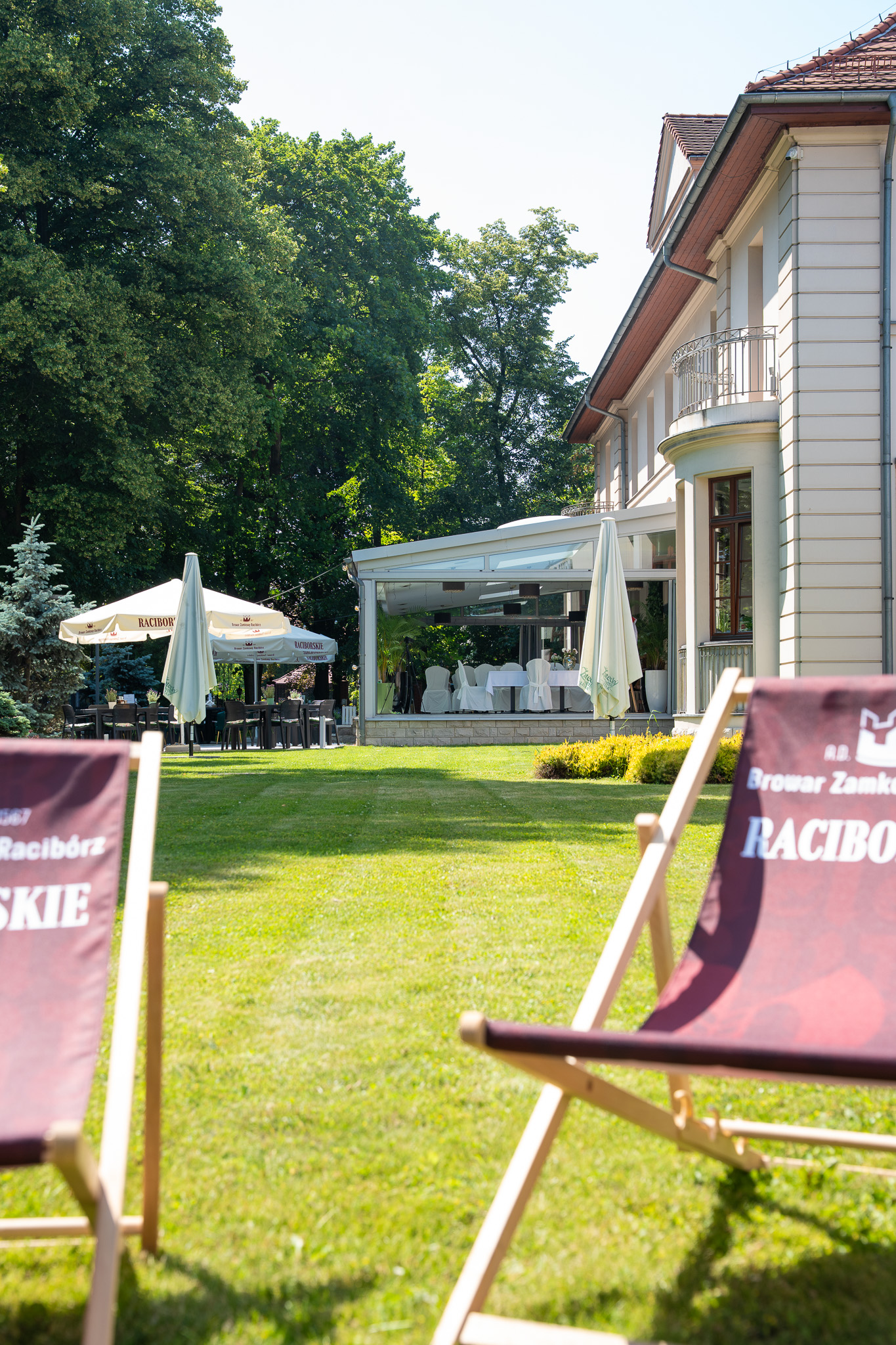 Hotel Gorczowski latem — patio z leżakami na trawniku