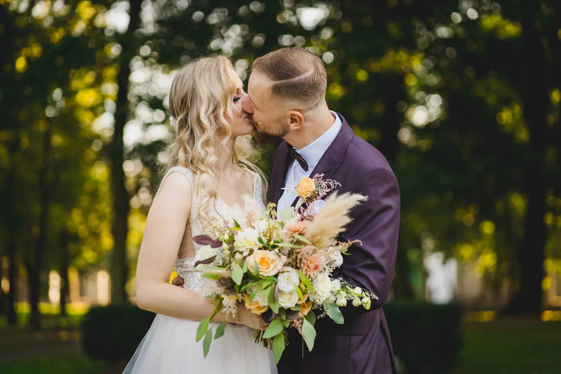 Para młoda całująca się wśród zieleni przy Hotelu Gorczowski